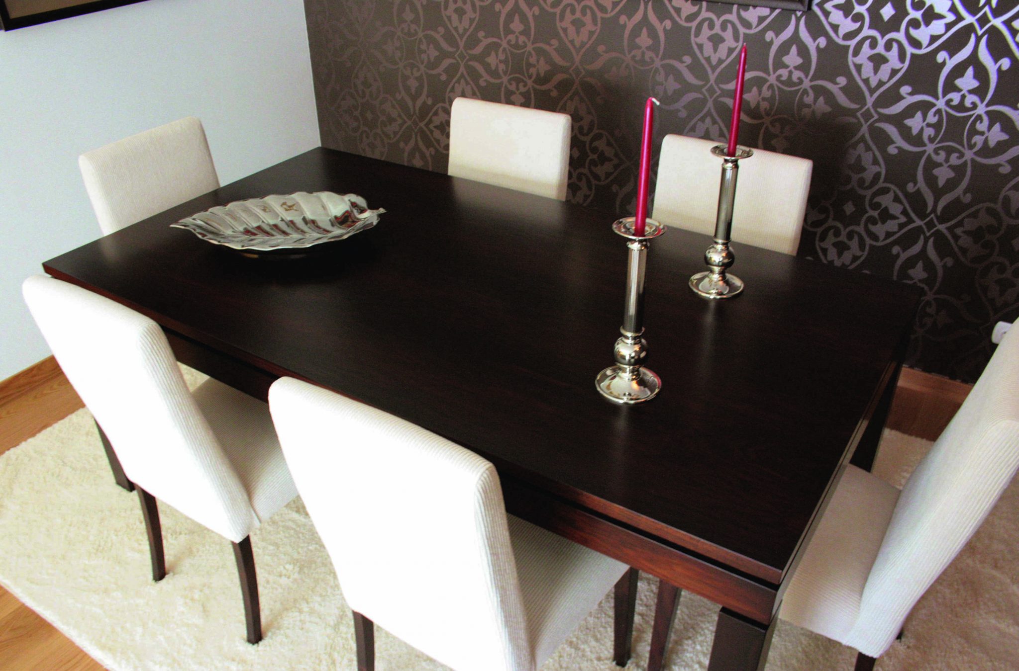 Sala de jantar com mesa em madeira escura e papel de parede